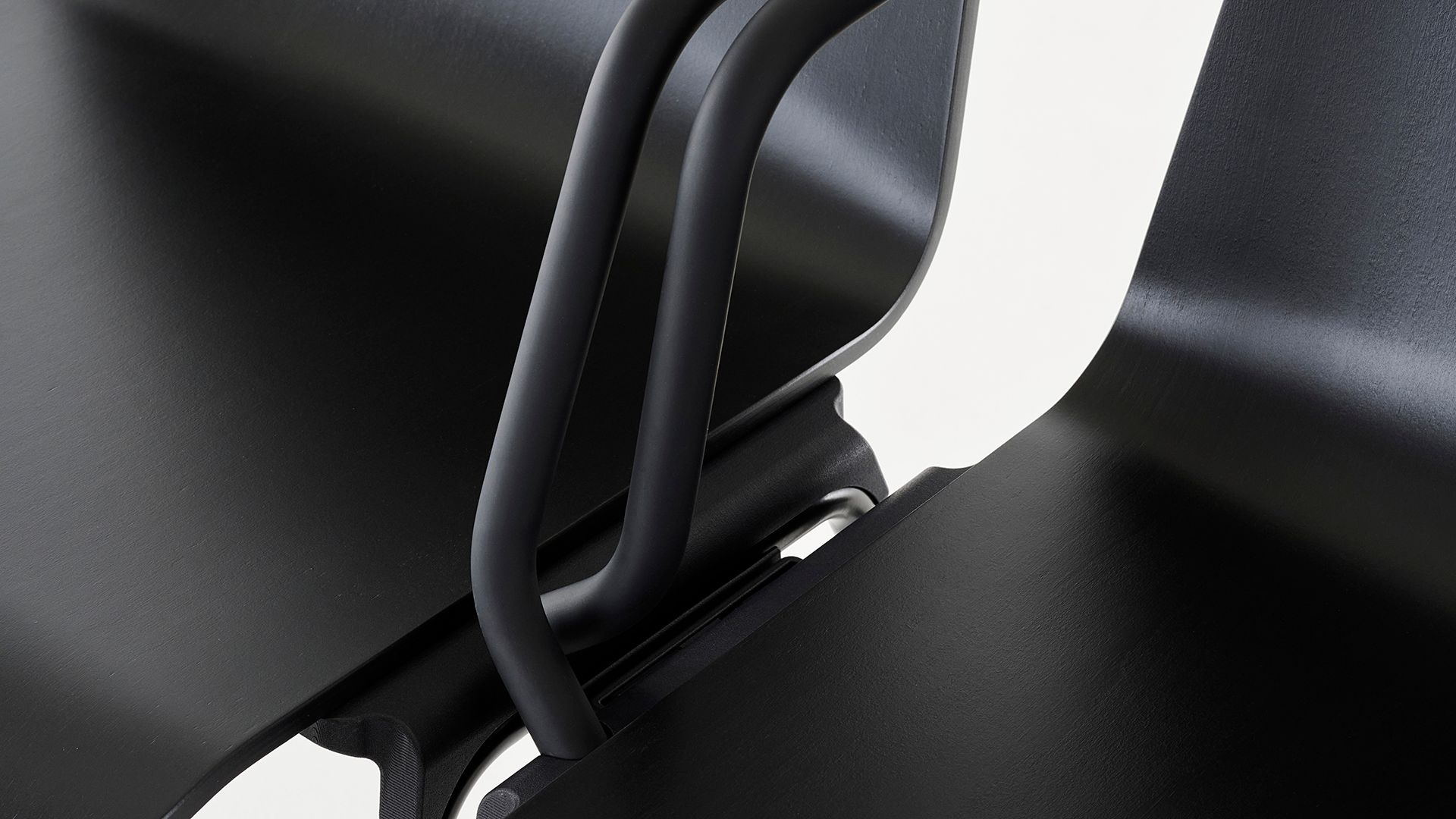 Detail of two connected black S 760 chairs for THONET